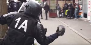 Un policier lance un pavé sur les manifestants du 1er mai